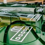 Witte iconen gedrukt op donkergroen plexiglas, rond gefreesd